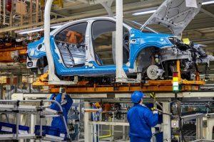 Les ouvriers installent le firmware de châssis de voiture sur la ligne de production de l’atelier de fabrication de Volkswagen de Shanghai
