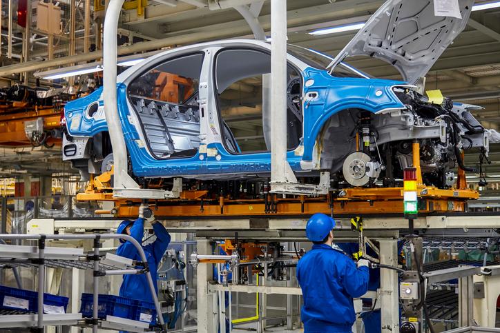 Les ouvriers installent le firmware de châssis de voiture sur la ligne de production de l’atelier de fabrication de Volkswagen de Shanghai